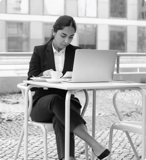 Professional reviewing certification information on a laptop outdoors